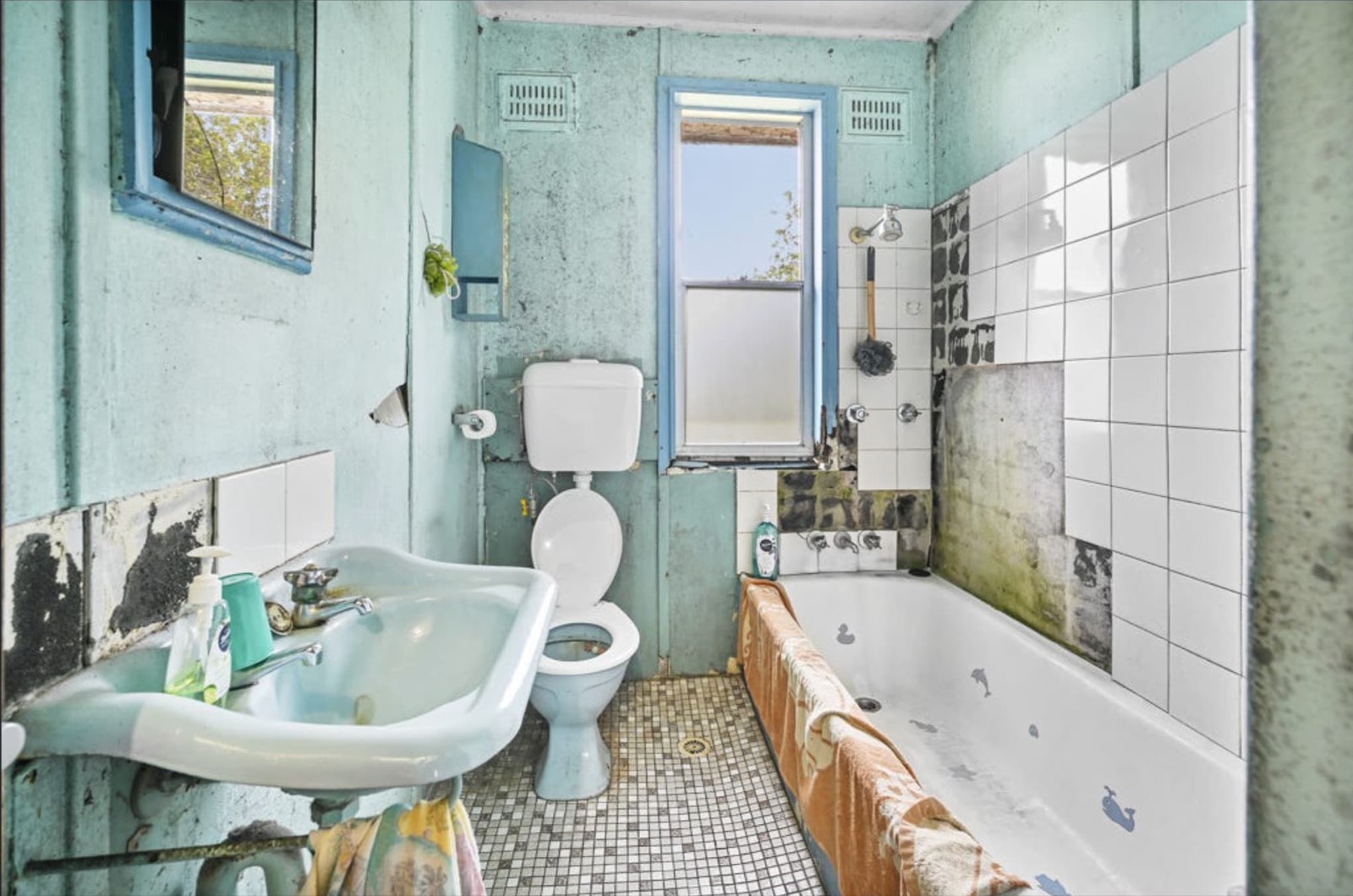 A rundown, mould-stained old bathroom in need of a full renovation